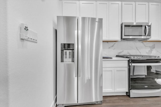 8609 San Giano Cv, Round Rock, TX 78665 - kitchen with appliances with stainless steel finishes, white cabinetry, wood finished floors, and light countertops