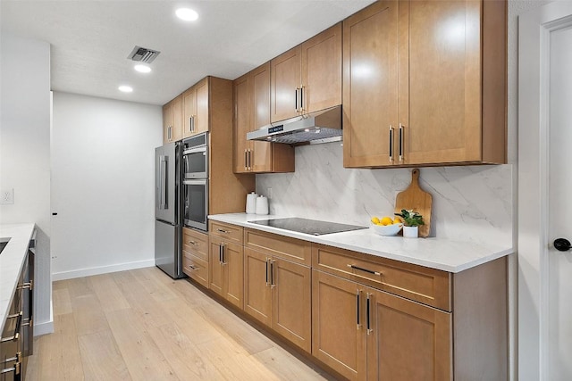 506 Explorer, Lakeway, TX 78734 - kitchen featuring under cabinet range hood, black electric cooktop, light wood-style flooring, tasteful backsplash, and recessed lighting