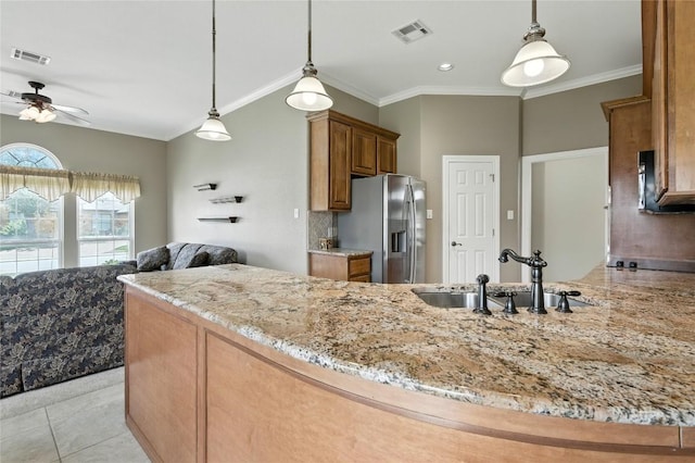 100 Davis Ct, Thorndale, TX 76577 - kitchen featuring stainless steel fridge, ceiling fan, brown cabinets, light stone countertops, and crown molding