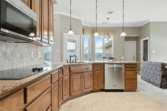 100 Davis Ct, Thorndale, TX 76577 - kitchen featuring stainless steel appliances, brown cabinetry, light tile patterned floors, decorative backsplash, and light stone countertops