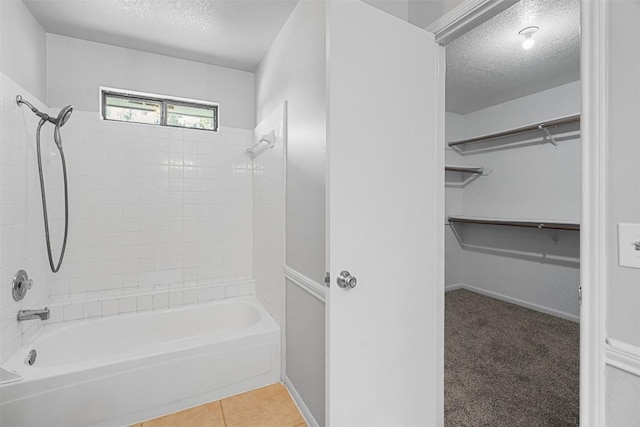 506 Turtle Back Cv, Killeen, TX 76542 - full bath with a textured ceiling, bathtub / shower combination, a spacious closet, and tile patterned floors