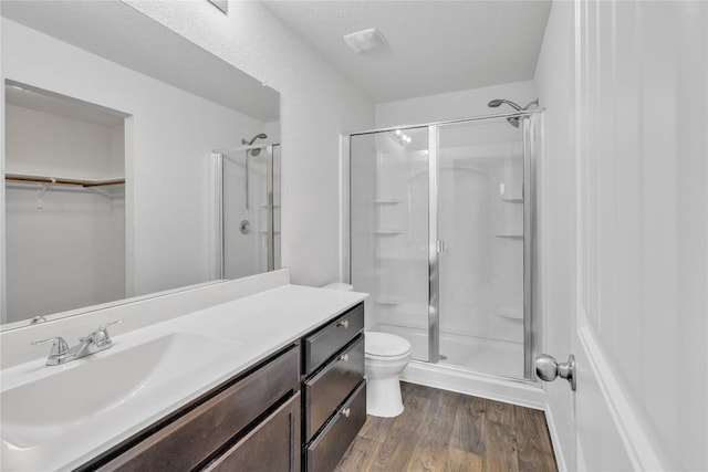 14802 Tuff Rd, Manor, TX 78653 - bathroom featuring a stall shower, wood finished floors, vanity, and a walk in closet