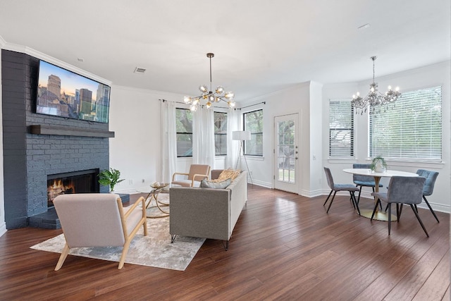 9402 Caracas Dr, Austin, TX 78733 - living area featuring a chandelier, wood finished floors, crown molding, and a brick fireplace