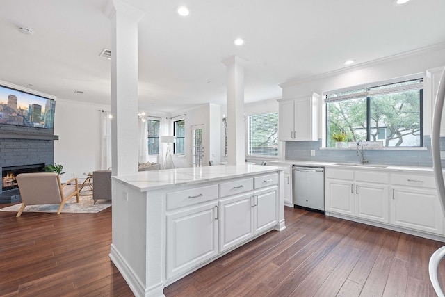 9402 Caracas Dr, Austin, TX 78733 - kitchen featuring stainless steel dishwasher, dark wood-style floors, crown molding, tasteful backsplash, and a fireplace