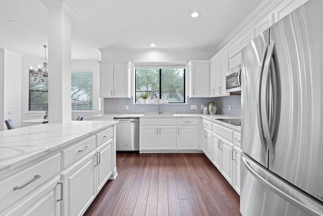 9402 Caracas Dr, Austin, TX 78733 - kitchen featuring stainless steel appliances, a chandelier, crown molding, backsplash, and dark wood-style floors
