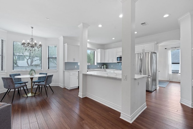 9402 Caracas Dr, Austin, TX 78733 - kitchen featuring appliances with stainless steel finishes, white cabinetry, dark wood-style floors, tasteful backsplash, and arched walkways