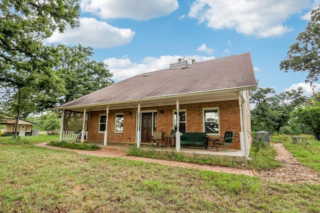 428 Gotier Trace Rd, Smithville, TX 78957 - back of property with brick siding, a yard, a porch, and a chimney