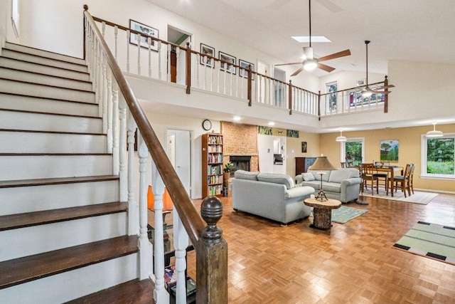 428 Gotier Trace Rd, Smithville, TX 78957 - living room featuring stairway, a ceiling fan, a fireplace, and a towering ceiling