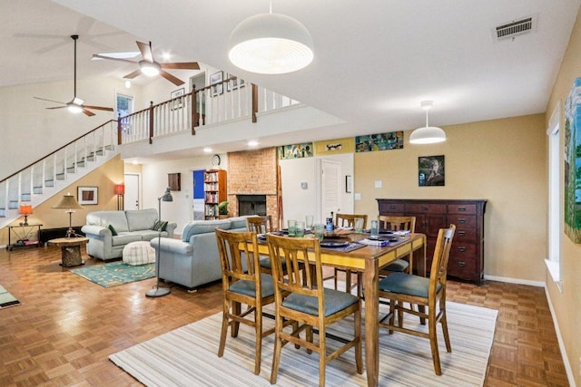 428 Gotier Trace Rd, Smithville, TX 78957 - dining room with ceiling fan, stairway, a large fireplace, and a high ceiling