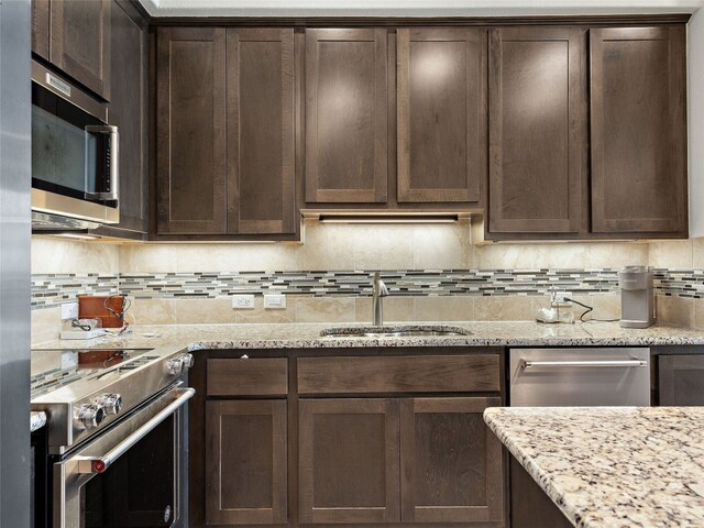 106 Bella Toscana Ave Unit 3204, Lakeway, TX 78734 - kitchen featuring appliances with stainless steel finishes, dark brown cabinets, backsplash, and light stone countertops