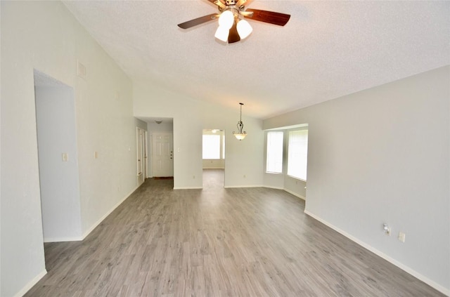 2200 Frontier Trl, Round Rock, TX 78681 - unfurnished living room with lofted ceiling, a textured ceiling, ceiling fan, and wood finished floors