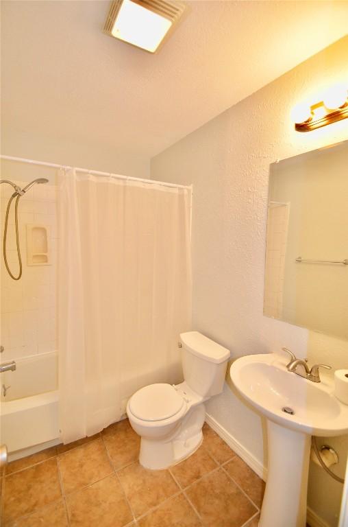 2200 Frontier Trl, Round Rock, TX 78681 - full bathroom with shower / bath combo with shower curtain, tile patterned floors, and a textured wall