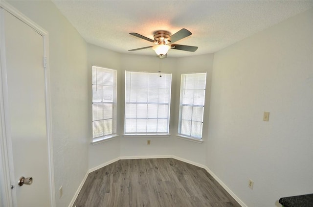 2200 Frontier Trl, Round Rock, TX 78681 - unfurnished room featuring a ceiling fan, plenty of natural light, dark wood finished floors, and a textured ceiling