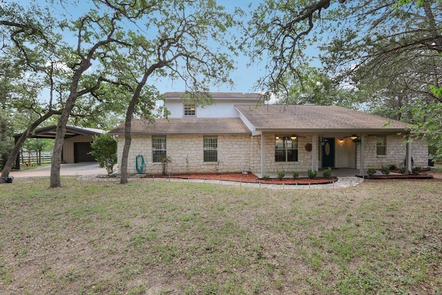 148 Oak Ridge Dr, Cedar Creek, TX 78612 - single story home with stone siding, a front yard, concrete driveway, a carport, and a porch