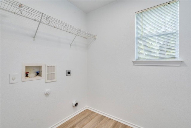 618 Lavaca Loop, Elgin, TX 78621 - laundry area with hookup for an electric dryer, gas dryer hookup, hookup for a washing machine, and light wood-type flooring