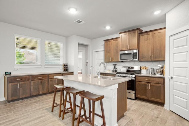 2705 Grizzly Way, Leander, TX 78641 - kitchen with stainless steel appliances, light wood-type flooring, tasteful backsplash, a kitchen breakfast bar, and recessed lighting