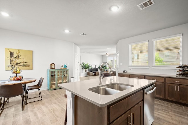 2705 Grizzly Way, Leander, TX 78641 - kitchen with stainless steel dishwasher, light wood-style flooring, light countertops, a kitchen island with sink, and recessed lighting