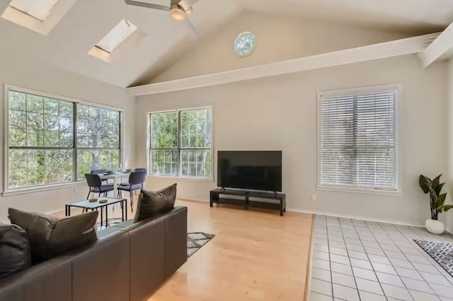 1202 Loma Dr, Austin, TX 78741 - living area featuring vaulted ceiling, ceiling fan, a skylight, and light tile patterned floors