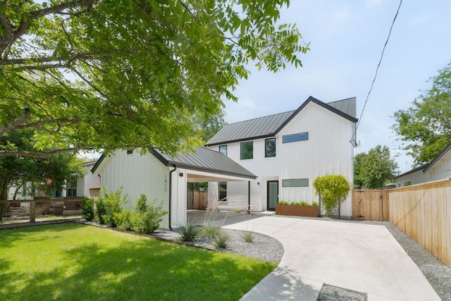 1911 Piedmont Ave, Austin, TX 78757 - back of property featuring a metal roof, a standing seam roof, board and batten siding, and driveway