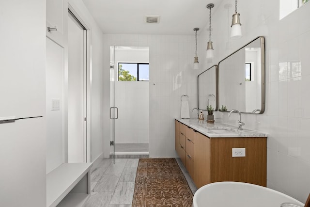 1911 Piedmont Ave, Austin, TX 78757 - bathroom featuring double vanity, a stall shower, a soaking tub, and tile walls