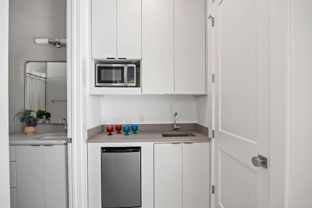 1911 Piedmont Ave, Austin, TX 78757 - kitchen with stainless steel microwave, refrigerator, white cabinets, and light countertops