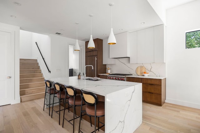 1911 Piedmont Ave, Austin, TX 78757 - kitchen featuring modern cabinets, light wood-type flooring, a kitchen breakfast bar, and recessed lighting