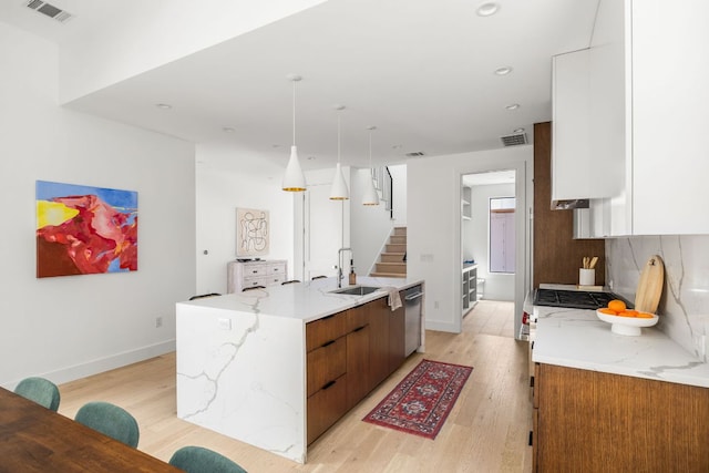 1911 Piedmont Ave, Austin, TX 78757 - kitchen with a spacious island, light wood-style floors, modern cabinets, dishwasher, and white cabinets