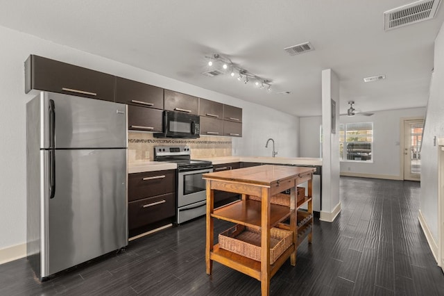 1101 Grove Blvd Unit 206, Austin, TX 78741 - kitchen featuring stainless steel appliances, light countertops, decorative backsplash, and dark wood finished floors