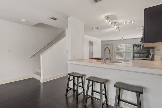 1101 Grove Blvd Unit 206, Austin, TX 78741 - kitchen with a peninsula, dark wood-style floors, a kitchen breakfast bar, light countertops, and stove