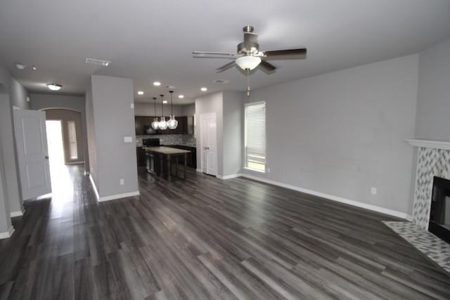 861 Stockdale Rd, Copperas Cove, TX 76522 - unfurnished living room featuring arched walkways, a ceiling fan, a high end fireplace, dark wood finished floors, and recessed lighting