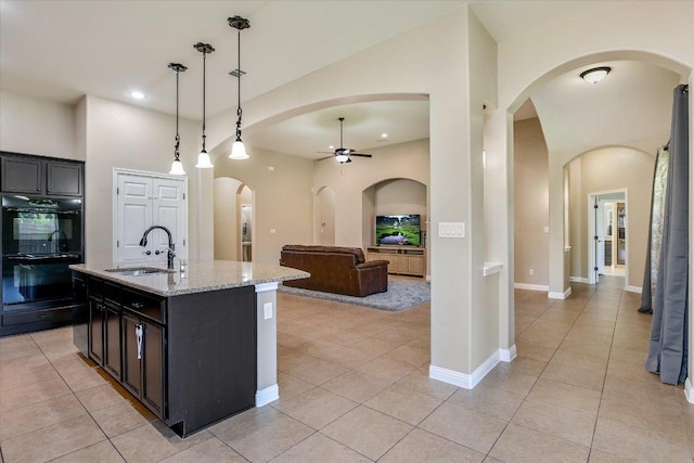 2944 Saint Federico Way, Round Rock, TX 78665 - kitchen featuring a ceiling fan, light tile patterned flooring, light stone countertops, arched walkways, and recessed lighting