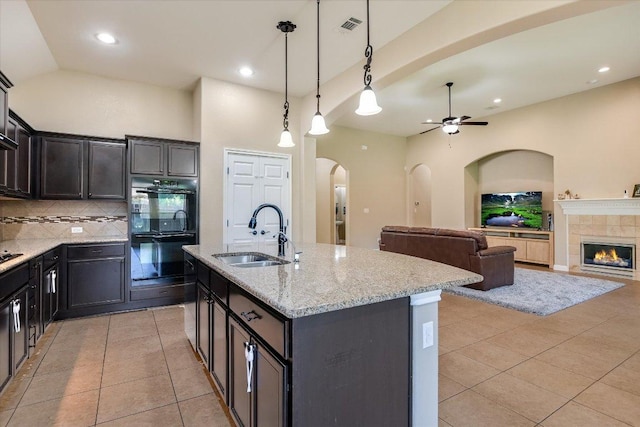 2944 Saint Federico Way, Round Rock, TX 78665 - kitchen with arched walkways, decorative backsplash, light tile patterned flooring, light stone countertops, and recessed lighting