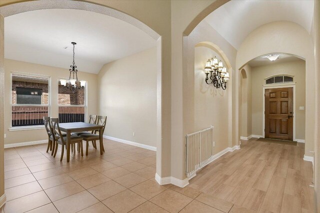 2944 Saint Federico Way, Round Rock, TX 78665 - dining room featuring a chandelier, arched walkways, vaulted ceiling, and light tile patterned floors