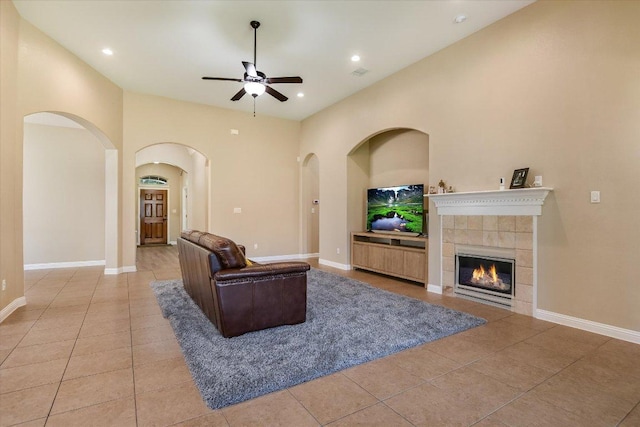 2944 Saint Federico Way, Round Rock, TX 78665 - living area featuring ceiling fan, light tile patterned floors, arched walkways, a tiled fireplace, and recessed lighting