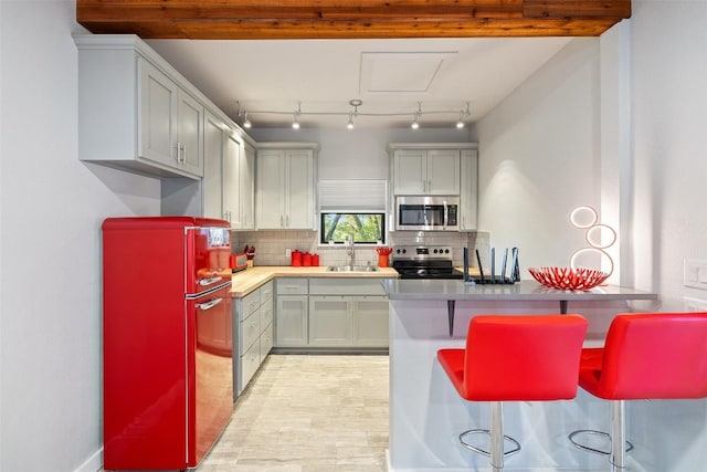 101 Rolling Hills Rd, Blanco, TX 78606 - kitchen with stainless steel appliances, tasteful backsplash, a kitchen breakfast bar, a peninsula, and light countertops