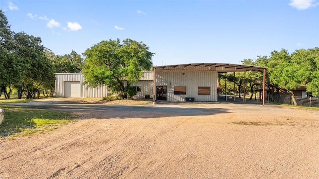 101 Rolling Hills Rd, Blanco, TX 78606 - view of front of property featuring an outdoor structure, dirt driveway, board and batten siding, and a detached garage