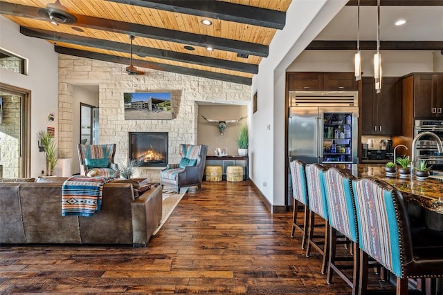 101 Rolling Hills Rd, Blanco, TX 78606 - living area with dark wood-style floors, a wooden ceiling with exposed beams, and a stone fireplace
