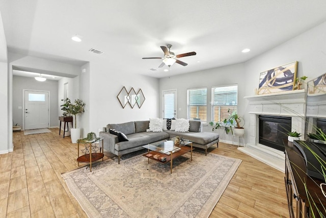 5512 Baythorne Dr, Austin, TX 78747 - living room with healthy amount of natural light, light wood finished floors, a premium fireplace, a ceiling fan, and recessed lighting