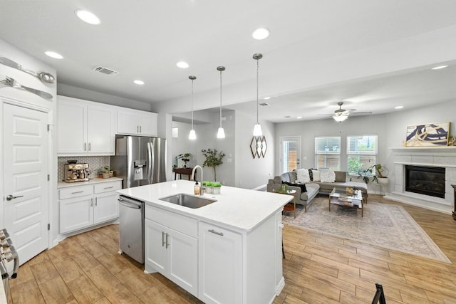 5512 Baythorne Dr, Austin, TX 78747 - kitchen featuring stainless steel appliances, open floor plan, light wood finished floors, light countertops, and a ceiling fan