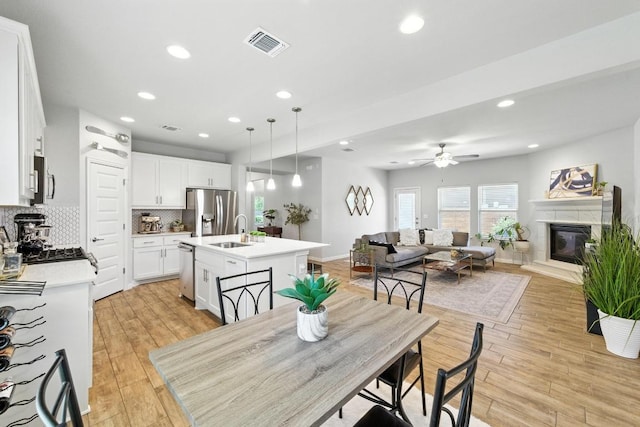 5512 Baythorne Dr, Austin, TX 78747 - dining room with a ceiling fan, light wood-style flooring, recessed lighting, and a glass covered fireplace