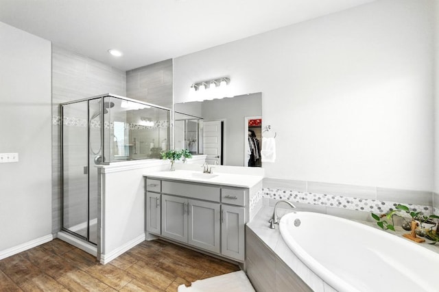5512 Baythorne Dr, Austin, TX 78747 - full bath with a bath, a stall shower, vanity, wood finished floors, and recessed lighting