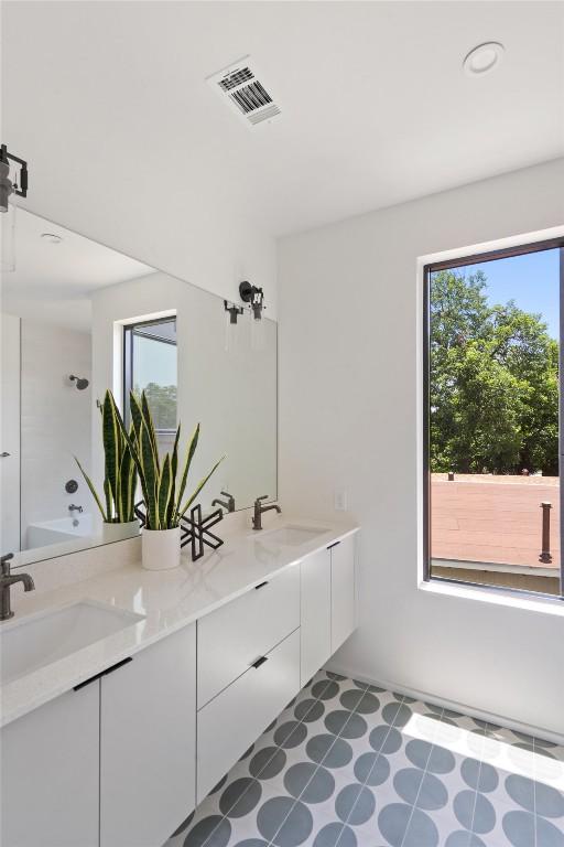 1203 Richcreek Rd, Austin, TX 78757 - full bath featuring double vanity, healthy amount of natural light, and bathtub / shower combination