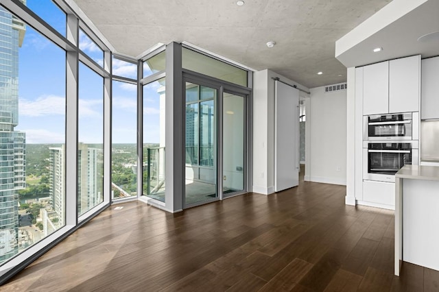 501 W Ave Unit 3201, Austin, TX 78701 - spare room with a wall of windows, dark wood-style flooring, a view of city, and a smoke detector
