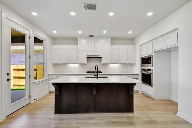 596 Biscayne Bay Bnd, Kyle, TX 78640 - kitchen with stainless steel appliances, an island with sink, tasteful backsplash, light countertops, and recessed lighting