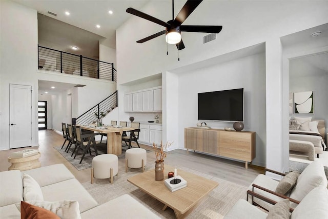 596 Biscayne Bay Bnd, Kyle, TX 78640 - living area featuring a high ceiling, ceiling fan, stairway, recessed lighting, and light wood-type flooring
