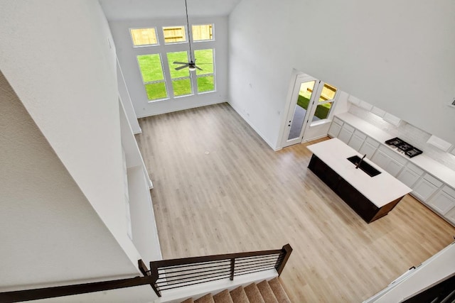 596 Biscayne Bay Bnd, Kyle, TX 78640 - unfurnished living room featuring wood finished floors, ceiling fan, and a high ceiling
