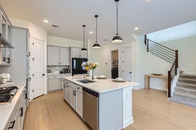 1505 Sibley Way, Leander, TX 78641 - kitchen featuring appliances with stainless steel finishes, gray cabinets, light wood-style floors, decorative backsplash, and recessed lighting