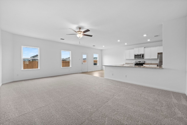 384 Low Pasture Trl, San Marcos, TX 78656 - unfurnished living room with light carpet, recessed lighting, and ceiling fan