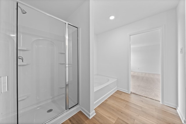 384 Low Pasture Trl, San Marcos, TX 78656 - full bath with wood finished floors, a shower stall, a bath, and recessed lighting