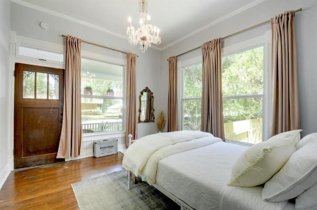 200 Garwood St, Smithville, TX 78957 - bedroom with wood finished floors, multiple windows, a chandelier, and crown molding
